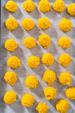 Beyaz çikolatalı limonlu kurabiye. Beyaz çikolatalı limonlu kurabiye pişirmek için parşömen kağıdıyla kaplı bir yemek tepsisine hamur kepçesiyle kurabiye pişirmek..