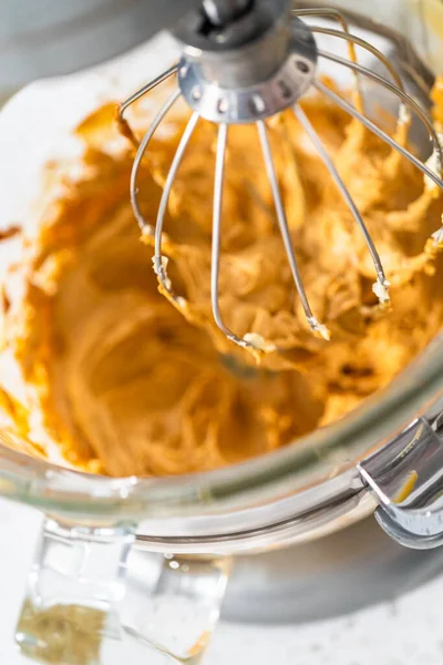 Whipping ingredients in a stand electric mixer to make dulce de leche buttercream frosting.