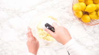 Düz yatıyordu. Adım adım. Limonlu kek hazırlamak için karıştırma kabındaki malzemeleri karıştırıyorum..