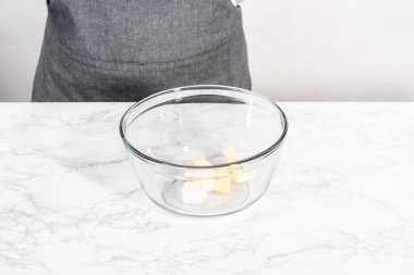 Krem peynirli çiseleme sosu hazırlamak için büyük bir bardakta karıştırma malzemesi..