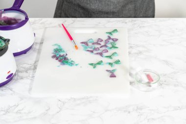 Silikon kalıplardan çikolata deniz kızı kuyrukları çıkarılıyor.