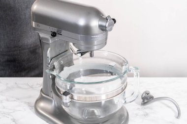 Büyük bir bardaktaki malzemeleri karıştırıyorum. Pizza hamuruyla karıştırıyorum..