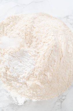 Kuru malzemeleri, büyük bir bardakta çırpma kabıyla karıştırarak Amerikan bayrağı mini kekleri pişiriyor..