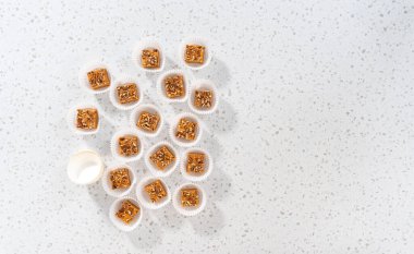 Düz yatıyordu. Ev yapımı balkabağı aromalı şekerleme parçaları mutfak tezgahında beyaz kağıt kapkek kalıplarında..