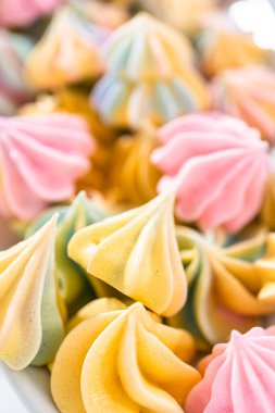 Beyaz servis tabağında çok renkli tek boynuzlu at kurabiyeleri..