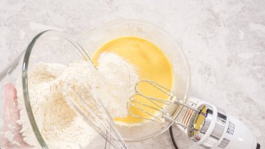 Düz yatıyordu. Adım adım. Fünyeli kek pişirmek için karıştırma kabındaki malzemeleri karıştırıyorum..