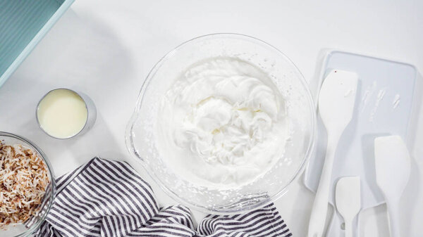 Плоский лежал. Смешивание ингредиентов в миске смешивания стекла для приготовления домашнего кокосового мороженого.