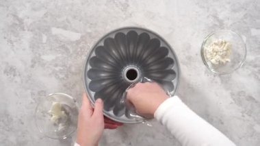 Time lapse. Flat lay. Step by step. Greasing bundt cake pan with vegetable shortening and sprinkling with white flour.