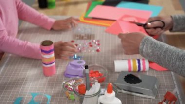 Close up view. Kids papercraft. Making paper bugs out of the empty toilet paper rolls and construction paper.
