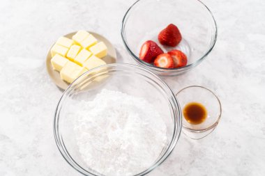 Çilekli tereyağlı kremayı hazırlamak için bardaktaki karışımlar..