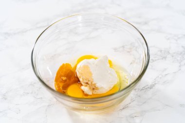 Küçük bir bardakta ıslak malzemeler karıştırmak mini vanilyalı kekler pişirmek için ombre pembe tereyağlı krema.