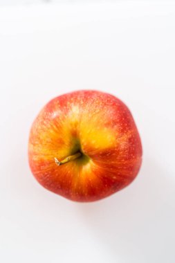 Kırmızı elmaları beyaz bir kesme tahtasının üzerinde ince dilimlere ayırmak.