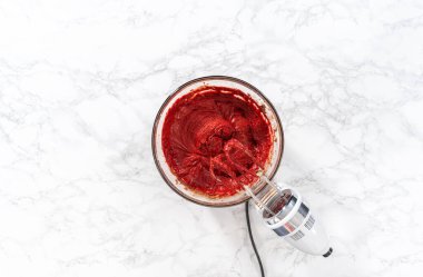 Düz yatıyordu. Büyük bir bardakta ıslak malzemeler karıştırarak kırmızı kadife kekler ve beyaz çikolatalı ganache kreması pişiriyorum..