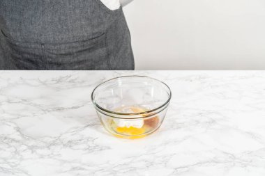 Küçük bir bardakta ıslak malzemeler karıştırmak mini vanilyalı kekler pişirmek için ombre pembe tereyağlı krema.