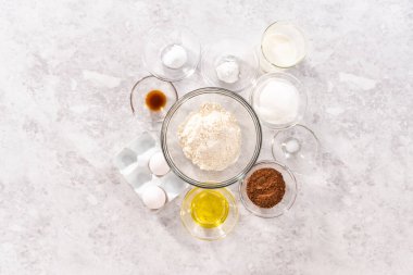 Flat lay. Ingredients in a glass mixing bowls to bake chocolate strawberry cupcakes.
