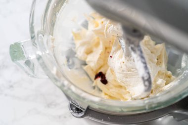 Mutfaktaki elektrikli mikserin içeriğini karıştırıp tereyağlı krema yapıyorum..