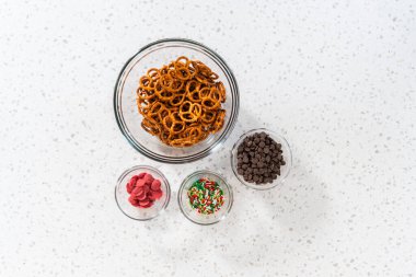 Flat lay. Measured ingredients in glass mixing bowls to make a chocolate pretzel Christmas wreath.