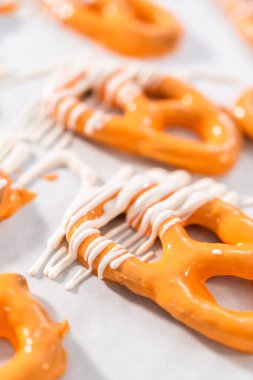 Çikolata soslu krakerlerin üzerine erimiş çikolata serpiştirmek..