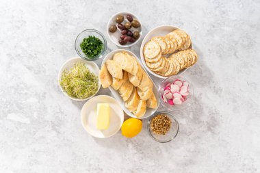 Düz yatıyordu. Tereyağı tahtasını sebze ve ekmekle karıştırmak için cam kaselerde ölçülmüş malzemeler..