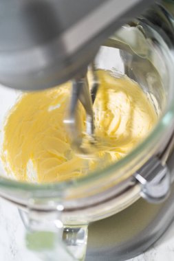 Mutfaktaki elektrikli mikserin içeriğini karıştırıp tereyağlı krema yapıyorum..