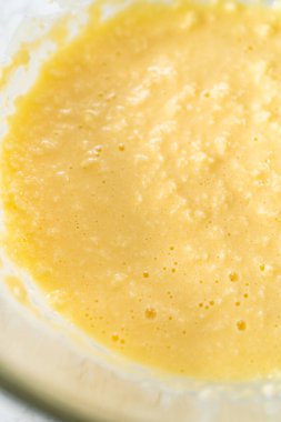 Mini vanilyalı kekler ve ombre pembe kremalı krema pişirmek için büyük bir karıştırma kabında malzemeler karıştırılıyor..