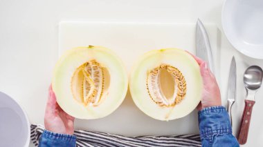 Adım adım. Düz yatıyordu. Beyaz kesme tahtasında kaygan altın çiğ taneli kavun.