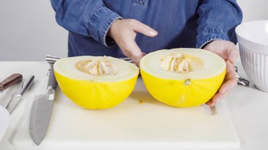 Adım adım. Beyaz kesme tahtasında kaygan altın çiğ taneli kavun.