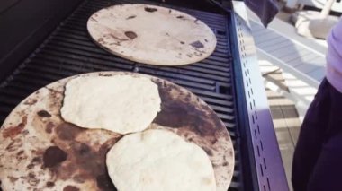 Gaz ızgarasında yassı ekmek pişiriyorum..