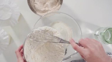 Time lapse. Flat lay. Measuring ingredients into a glass bowl to bake cinnamon rolls.