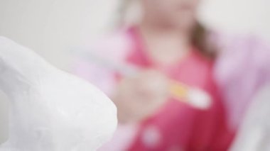 Evde resim dersinde kağıt heykel boyayan küçük bir kız..