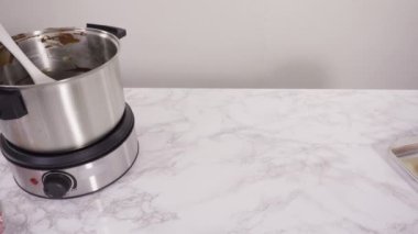 Adım adım. Çikolata parçacıkları eriyen kaplarda eriyor..