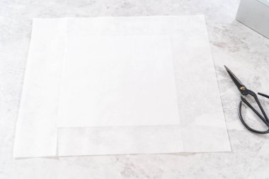 Yumurta likörü hazırlamak için kare cheesecake tavasını parşömen kağıdıyla kaplamak.