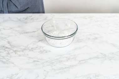 Küçük Paskalya ekmeği için limon jölesi yapmak için karışımı büyük bir karıştırıcı ile karıştırıyorum..