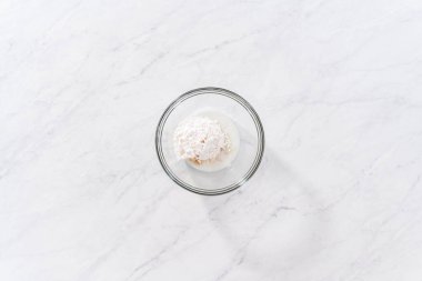 Flat lay. Preparing a white bread glaze in a glass mixing bowl.