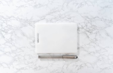 Empty a white cutting board on a marble surface.