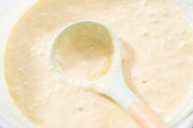 Hindistan cevizli muzlu krep yapmak için cam karıştırma kabında krep hamuru..