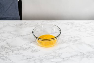 Küçük Paskalya ekmeği pişirmek için ıslak malzemeleri büyük bir bardakta karıştırıyorum..