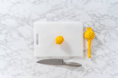 Beyaz bir kesme tahtasının üzerinde taze limon zıp zıp..