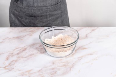 Elmalı yulaflı kurabiye pişirmek için büyük bir bardakta karıştırma malzemesi..