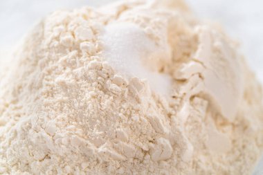 Kuru malzemeleri büyük bir bardakta çırpma kabıyla karıştırıp mini Paskalya ekmeği pişirmek..