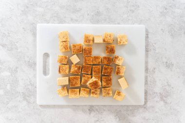 Flat lay. Homemade eggnog fudge pieces on a white cutting board.