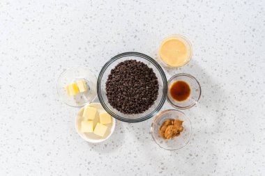 Düz yatıyordu. Fıstık ezmeli çikolata yapmak için cam karıştırma kabında ölçülmüş malzemeler..