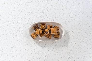 Düz yatıyordu. Fıstık ezmeli ve beyaz servis tabağında bulunan ev yapımı çikolatalı şekerleme..