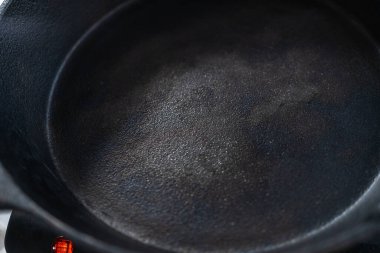 Ispanak ve jambonlu frittata hazırlamak için sobanın üzerinde dökme demir tava var..