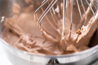 Ev yapımı çikolatalı dondurma yapmak için mutfak mikserinin malzemelerini karıştırıyorum..