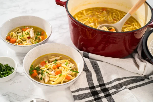 Beyaz seramik çorba kaselerinde kluski şehriyeli tavuk çorbası servis ediyorum..