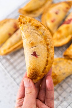 Mutfak tezgahındaki tavada taze pişmiş vişneli börek var..