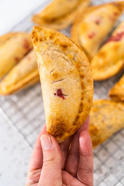 Mutfak tezgahındaki tavada taze pişmiş vişneli börek var..