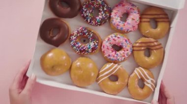 Düz yatıyordu. Beyaz bir karton kutuda mağazadan alınmış donutların çeşitliliği.