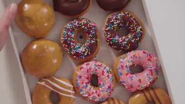 Düz yatıyordu. Beyaz bir karton kutuda mağazadan alınmış donutların çeşitliliği.